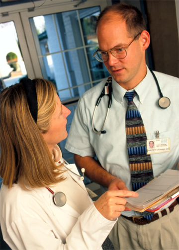 Two physicians with stethoscopes speaking to one another